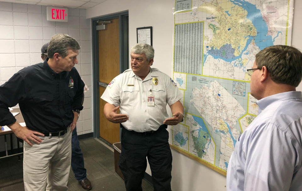 In this Sept. 17, 2018 photo, Craven County Emergency Services Director Stanley Kite, center, discusses flooding and damage caused by Hurricane Florence with North Carolina Democratic Gov. Roy Cooper, left, and Republican state House Speaker Tim Moore, right, in New Bern, N.C. Cooper has been praised by man, including Republicans, for his handling of the state’s immediate response to Florence. (AP Photo/Gary D. Robertson)