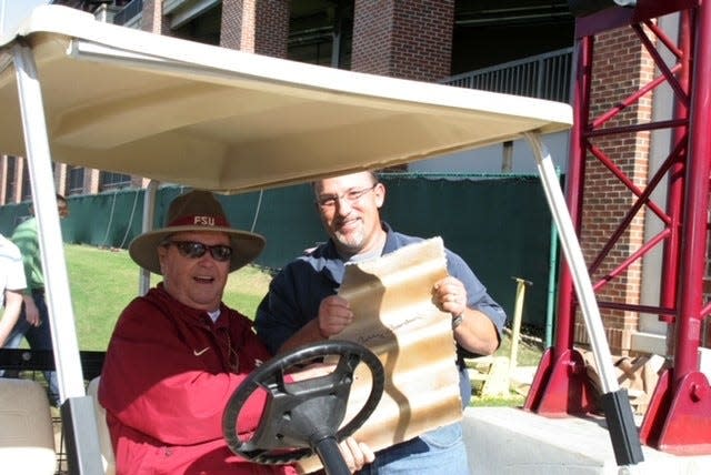 FSU's Director of Baseball Operations Chip Baker holds a piece of metal from the old Pensacola Street tunnel that was autographed by FSU football coach Bobby Bowden.