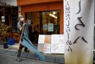 Sixty-year-old Yashiro Haga holds a curtain as he prepares for the opening of his ramen noodle shop 'Shirohachi', amid the coronavirus disease (COVID-19) outbreak, in Tokyo