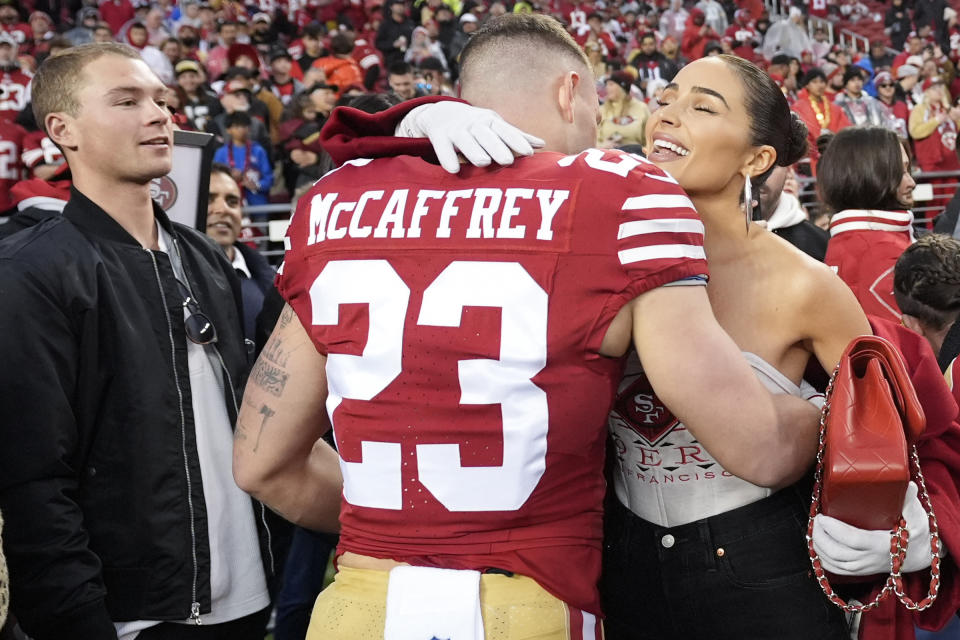 FILE - San Francisco 49ers running back Christian McCaffrey (23) hugs his girlfriend Olivia Culpo before an NFL football NFC divisional playoff game against the Green Bay Packers in Santa Clara, Calif., on Jan. 20, 2024. (AP Photo/Ashley Landis, File)