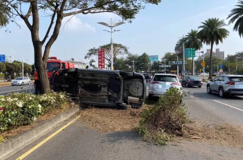 ▲大年初二、11日下午，高雄市19歲杜姓男子，駕駛汽車行經小港區平和東路口時，不慎擦撞中央分隔島及路樹，整台車翻覆、波及對向來車，釀2車碰撞4處擦挫傷送醫。（圖／翻攝畫面）