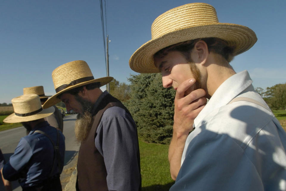 FILE - In this Monday, Oct. 2, 2006, Amish men gather across the street from the one-room schoolhouse in Nickel Mines, Pa., after a fatal shooting at the school. An example of Anabaptist values is the response of the Amish community around Nickel Mines, after a gunman killed five Amish schoolgirls and wounded five more in 2006 before taking his own life. Local Amish immediately expressed forgiveness for the killer and supported his widow. “If we do not forgive, how can we expect to be forgiven?” the Amish leaders said in a statement. (John Makely/The Baltimore Sun via AP)