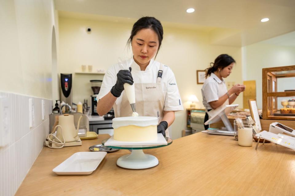 Ellie You, owner of Harucake, decorates a cake at her shop.