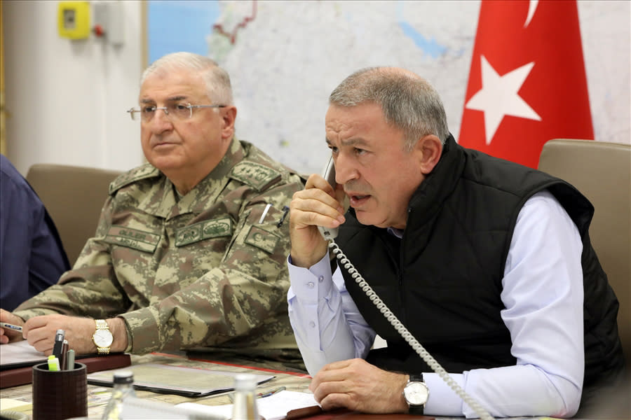 Turkey's Defense Minister Hulusi Akar, right, speaks on the phone alongside Chief of the General Staff of the Turkish Armed Forces Gen. Yasar Guler in an operation room at army headquarters in Ankara, Turkey, Wednesday, Oct. 9, 2019. Turkey's Defense Ministry says Turkish ground forces have moved across the border to fight against Kurdish fighters in northeastern Syria, hours after Turkish jet and artillery pounded areas in Syria's northern border. (Turkish Defence Ministry via AP, Pool)