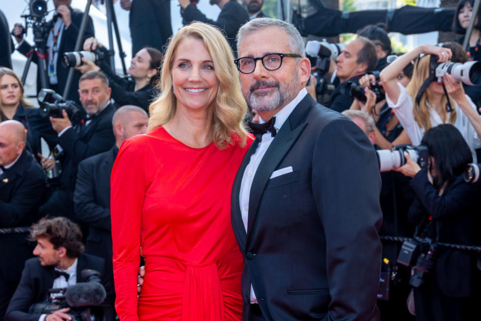 Close-up of Nancy and Steve smiling at a media event with paparazzi behind them