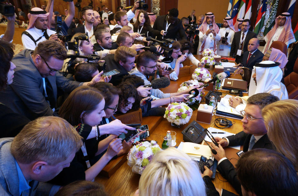Reporters surround the stage before a meeting of energy ministers from OPEC and its allies to discuss prices and production cuts, in Jiddah, Saudi Arabia, Sunday, May 19, 2019. The meeting takes places as tensions flare in the Persian Gulf after the U.S. ordered bombers and an aircraft carrier to the region over an unexplained threat they perceive from Iran, which comes a year after the U.S. unilaterally pulled out of Tehran's nuclear deal with world powers and reimposed sanctions on Iranian oil. (AP Photo/Amr Nabil)
