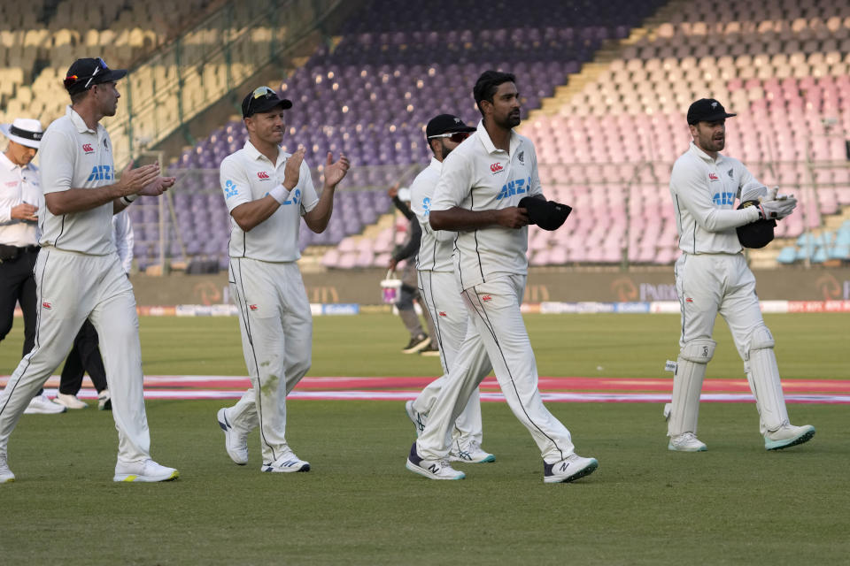 New Zealand's players clap for teammate Ish Sodhi, second right, who took 7 wickets in second innings, as they walk off the field on the end of Pakistan's innings during the fifth day of first test cricket match between Pakistan and New Zealand, in Karachi, Pakistan, Friday, Dec. 30, 2022. (AP Photo/Fareed Khan)