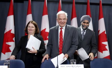 Canada's Immigration Minister John McCallum (C) arrives at a news conference with Health Minister Jane Philpott (L) and Defence Minister Harjit Sajjan in Ottawa, Canada November 24, 2015. REUTERS/Chris Wattie