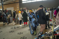 Visitors to the Afriski ski resort near Butha-Buthe, Lesotho, one wearing a traditional Basutu blanket, wait to rent ski gear Saturday July 30, 2022. While millions across Europe sweat through a summer of record-breaking heat, Afriski in the Maluti Mountains is Africa's only operating ski resort south of the equator. It draws people from neighboring South Africa and further afield by offering a unique experience to go skiing in southern Africa. (AP Photo/Jerome Delay)