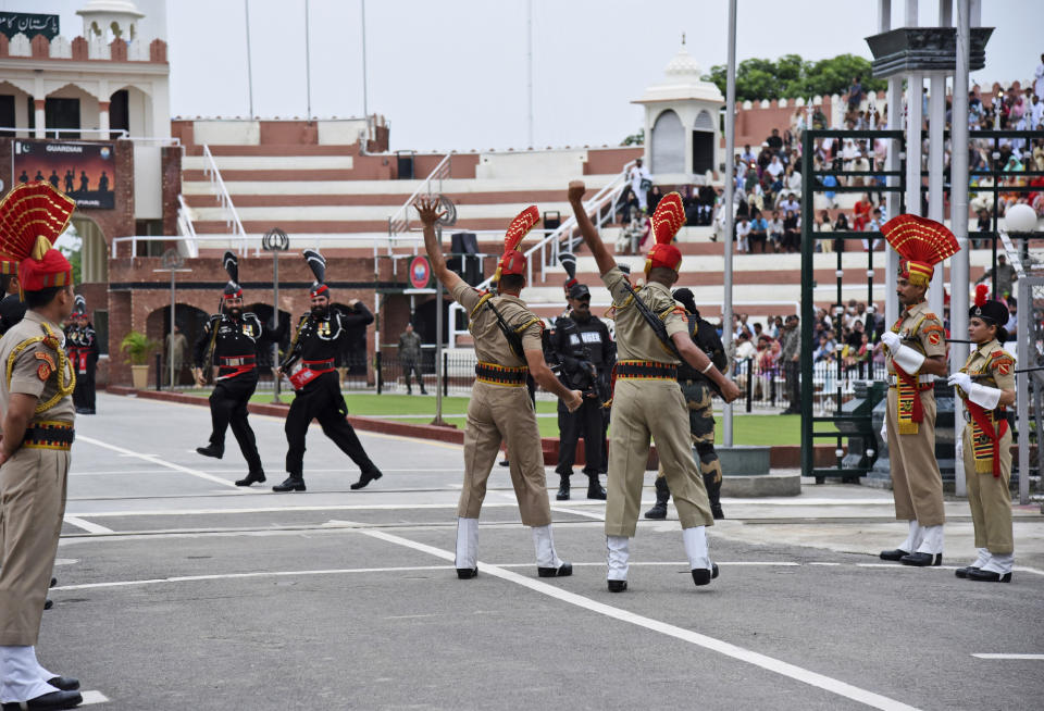 Pakistan Rangers soldiers, in black, face Indian Border Security Force soldiers at a daily closing ceremony on the Indian side of the Attari-Wagah border, Friday, Aug. 9, 2019. About 8,000 supporters of a Pakistani Islamist party are marching toward the Indian embassy in Islamabad to denounce New Delhi's actions to change the special status of the disputed Himalayan region of Kashmir. Both Pakistan and India claim all of Kashmir. Tensions have soared this week after India downgraded the Muslim-majority region's status from statehood to a territory. (AP Photo/Prabhjot Gill)