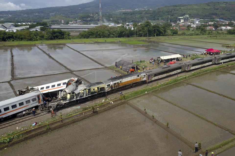 Rescuers inspect the wreckage after a collision between two trains in Cicalengka, West Java, Indonesia, Friday, Jan. 5, 2024. The trains collided on Indonesia's main island of Java on Friday, causing several carriages to buckle and overturn, officials said. (AP Photo/Achmad Ibrahim)