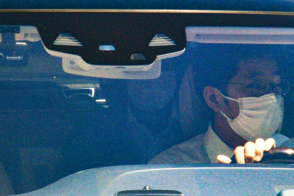 Haruyuki Takahashi, a former Tokyo Olympic organizing committee board member, rides on the back seats of a car as he leaves his home in Tokyo Wednesday, Aug. 17, 2022. Takahashi and three people from a clothing company that was a surprise sponsor of the 2020 Games were arrested on bribery suspicions Wednesday. (Kyodo News via AP)