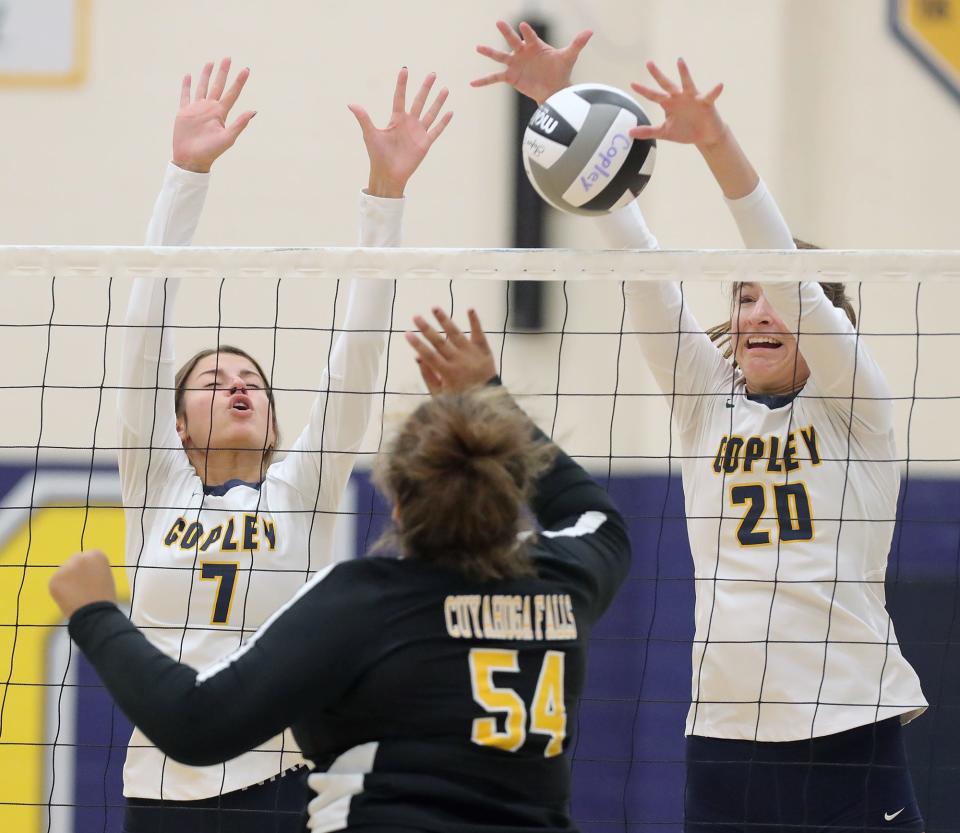 Copley's Allie Poundstone, left, and Alexa Strandberg, right, attempt to block a ball hit by Cuyahoga Falls' Berlynn Frashuer during the second set of a volleyball match, Tuesday, Sept. 6, 2022, in Copley, Ohio.