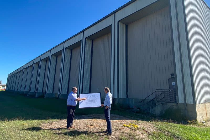 UCore executives pose with blueprints for new rare earth processing equipment in Alexandria