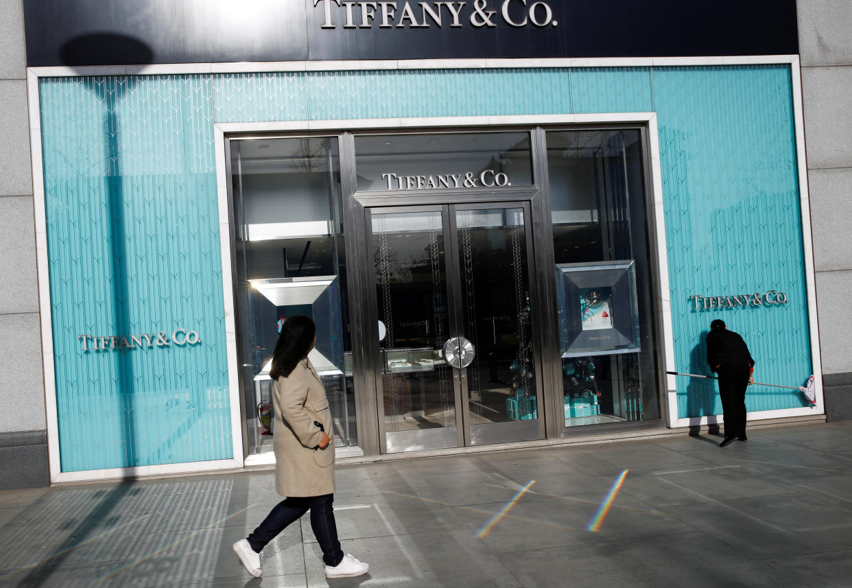 A woman cleans the windows at a Tiffany & Co. store in a luxury shopping street in Beijing, December 4, 2018.  REUTERS/Thomas Peter