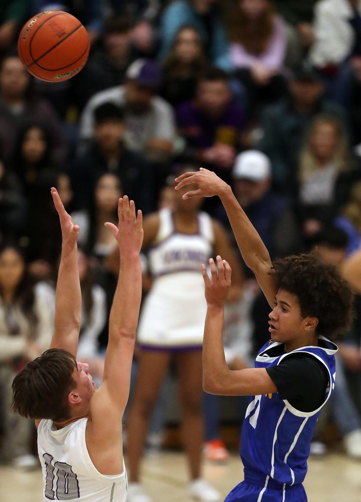 Bremerton’s Jalen Davis, right, makes a pass over North Kitsap’s Cade Orness on Tuesday, Jan. 9, 2024.