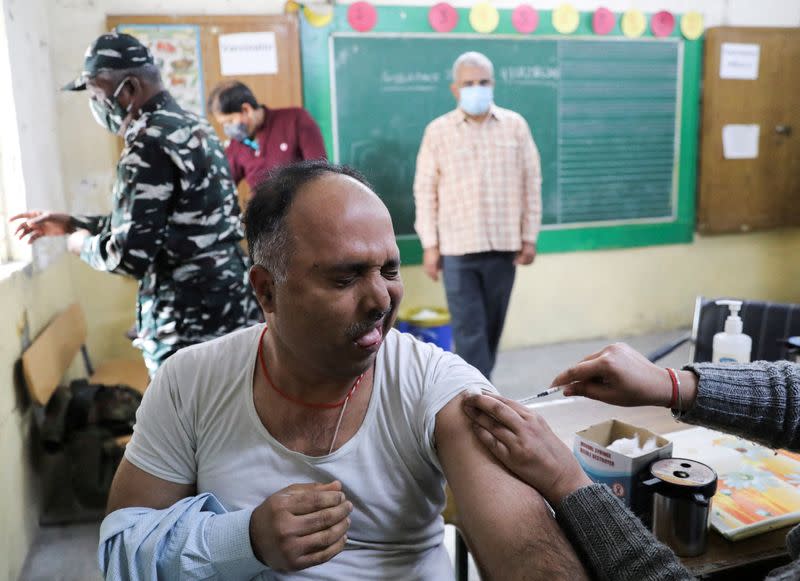 FILE PHOTO: A man reacts as he receives a dose of the COVISHIELD vaccine, against the coronavirus disease (COVID-19), manufactured by Serum Institute of India, at a vaccination centre in New Delhi