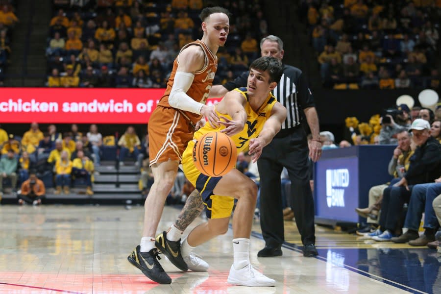 West Virginia guard Kerr Kriisa (3) is defended by Texas guard Chendall Weaver (2) during the second half of an NCAA college basketball game on Saturday, Jan. 13, 2024, in Morgantown, W.Va. (AP Photo/Kathleen Batten)