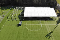 In this aerial drone photo, workers erect a temporary field hospital for use by people unable to isolate and recover from COVID-19 in their own homes on a soccer field Thursday, March 19, 2020, in the Seattle suburb of Shoreline, Wash. The field hospital will provide up to 200 beds, according to a city website, and will house "people exposed to, at risk of exposure, or becoming ill with the novel coronavirus." (AP Photo/Elaine Thompson)