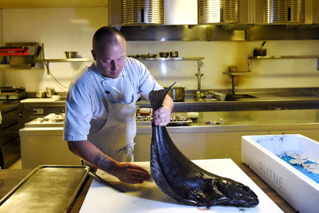 Chef Christopher Haatuft prepares a halibut from the Glitne company farm at his restaurant Lysverket in Bergen, Norway, July 31, 2018. REUTERS/Clodagh Kilcoyne