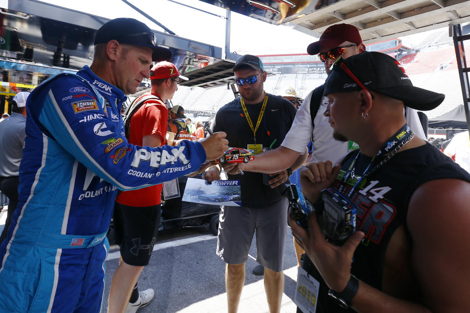 Driver Clint Bowyer signs autographs before practice for a NASCAR Cup Series auto race, Friday, Aug. 16, 2019, in Bristol, Tenn. (AP Photo/Wade Payne)
