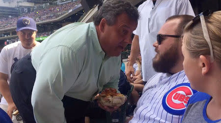 New Jersey Governor Chris Christie (L) confronts a Chicago Cubs baseball fan during game between the Milwaukee Brewers and the Chicago Cubs in Milwaukee, Wisconsin, U.S., July 30, 2017, in this still photo taken from video and provided July 31, 2017. Courtesy WISN-TV/ABC/Handout via REUTERS