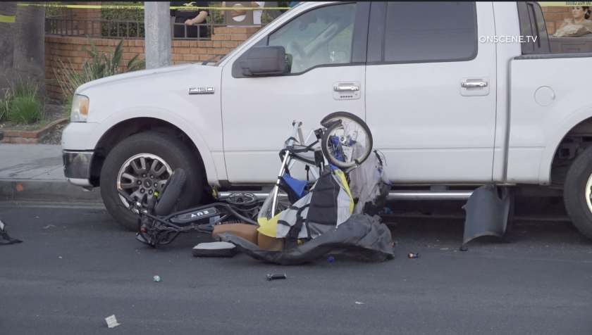 A crumpled piece of biking equipment for children lies in the road.