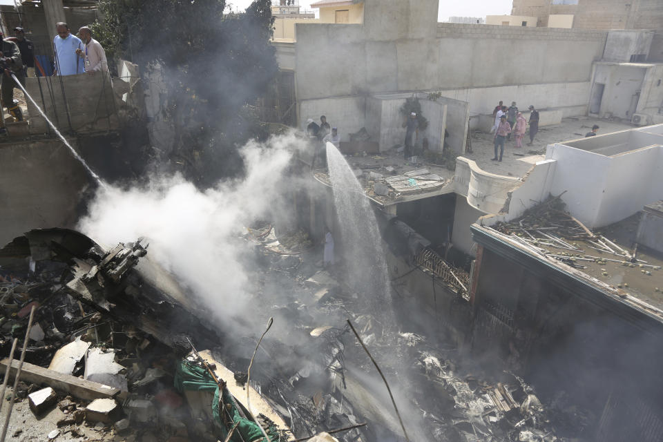 Fire brigade staff try to put out fire caused by plane crash in Karachi, Pakistan, Friday, May 22, 2020. An aviation official says a passenger plane belonging to state-run Pakistan International Airlines carrying more than 100 passengers and crew has crashed near the southern port city of Karachi. There were no immediate reports on the number of casualties. (AP Photo/Fareed Khan)