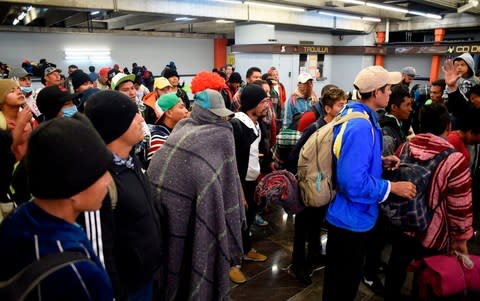 A group of Central American migrants heading in a caravan to the US, wait to take the metro at Ciudad Deportiva station in Mexico City - Credit: Alfredo ESTRELLA / AF