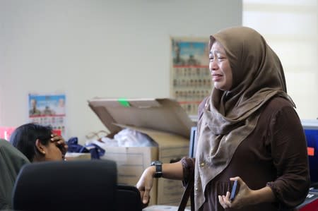 Employees of Utusan Malaysia react after the termination announcement at the company's headquarters in Kuala Lumpur