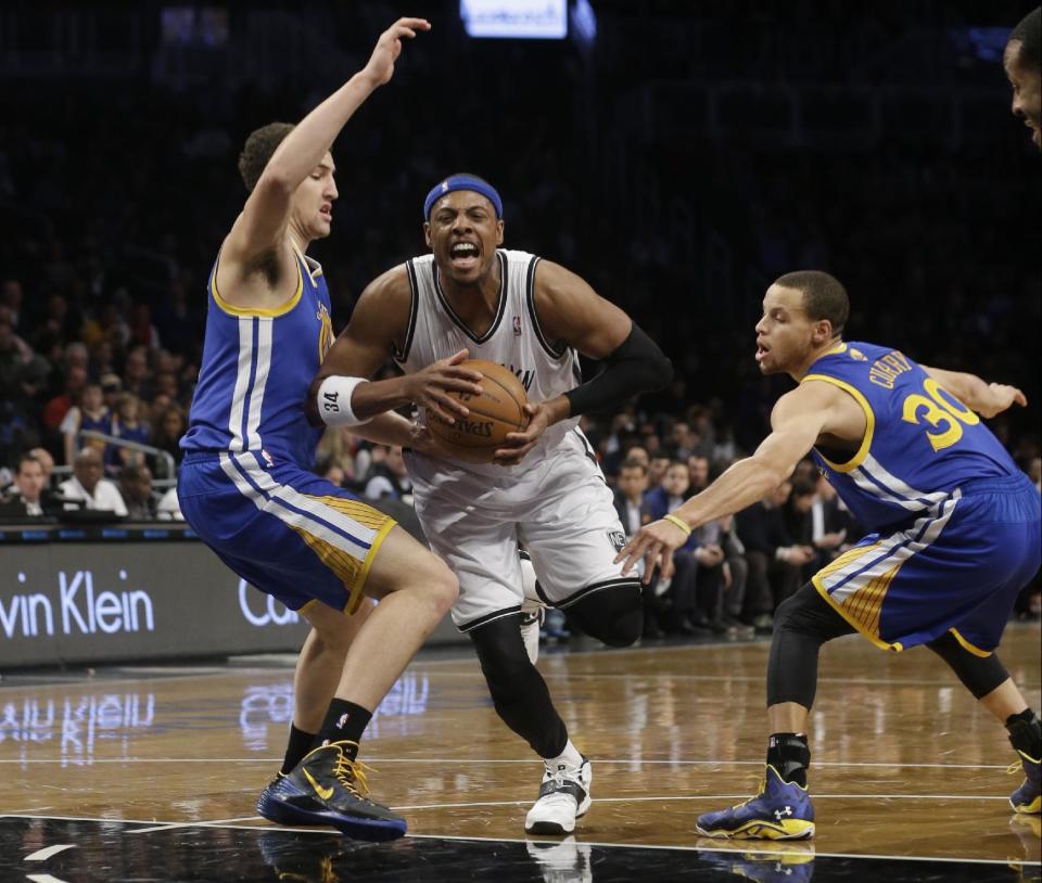 Brooklyn Nets' Paul Pierce (34) drives past Golden State Warriors' Stephen Curry (30) and Andrew Bogut (12), of Australia, during the first half of an NBA basketball game Wednesday, Jan. 8, 2014, in New York. (AP Photo/Frank Franklin II)