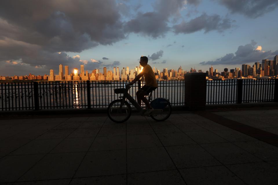 A person rides a bike along the Hudson River waterfront, in West New York, NJ.  Tuesday, August 2, 2022