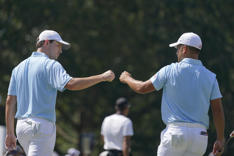 Patrick Cantlay, left, and Xander Schauffele celebrate on the fifth green during their foursomes match at the Presidents Cup golf tournament at the Quail Hollow Club, Thursday, Sept. 22, 2022, in Charlotte, N.C. (AP Photo/Julio Cortez)