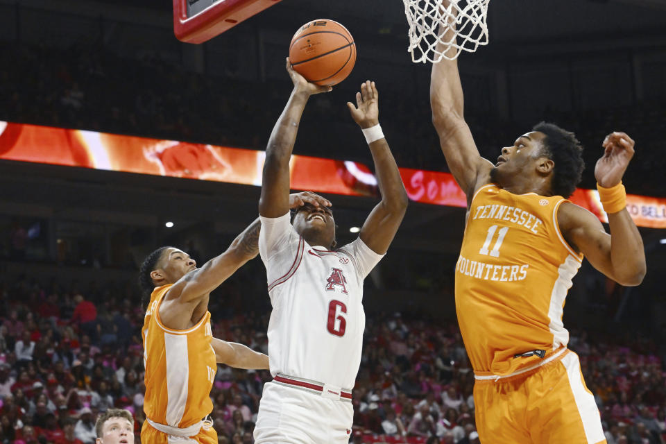 Arkansas guard Layden Blocker (6) looks for a shot against Tennessee defenders Zakai Zeigler, left, and Tobe Awaka during the second half of an NCAA college basketball game Wednesday, Feb. 14, 2024, in Fayetteville, Ark. (AP Photo/Michael Woods)