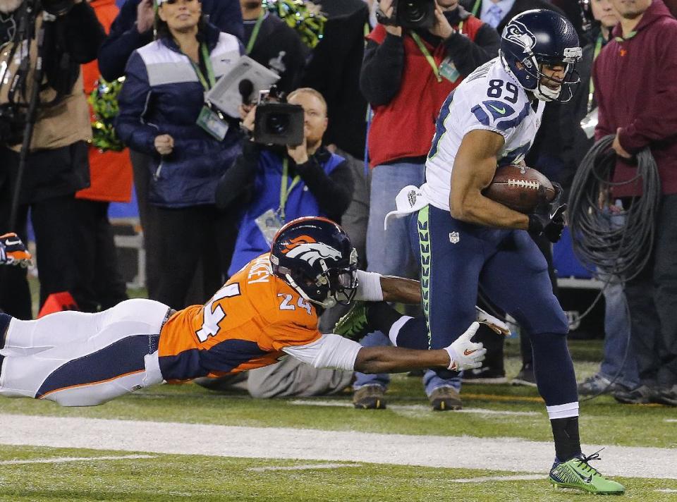 Denver Broncos cornerback Champ Bailey (24) reaches for Seattle Seahawks wide receiver Doug Baldwin (89) during the first half of the NFL Super Bowl XLVIII football game Sunday, Feb. 2, 2014, in East Rutherford, N.J. (AP Photo/Matt York)