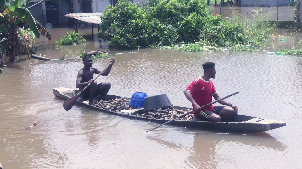 FILE - People paddle a canoe along flooded residential streets after a heavy downpour in Bayelsa, Nigeria, Oct. 20, 2022. In many Middle Eastern and African nations, climatic shocks killed hundreds and displaced thousands every year, causing worsening food shortages. With limited resources, they also are among the world’s poorest and most vulnerable to climate change impacts. (AP Photo/Reed Joshua, File)