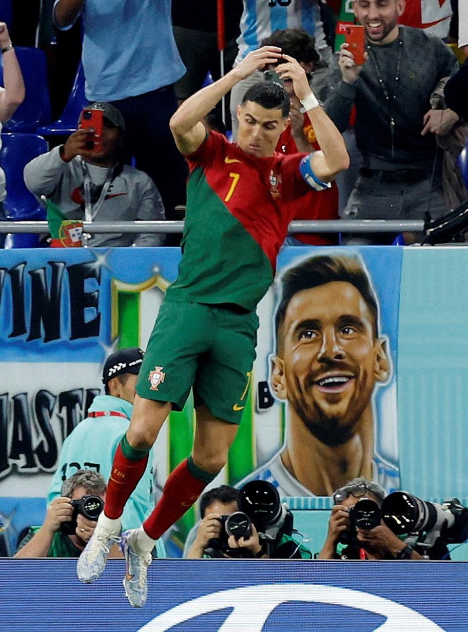 Portugal’s Cristiano Ronaldo celebrates scoring their first goal with a banner of Argentina’s Lionel Messi in the background (REUTERS)