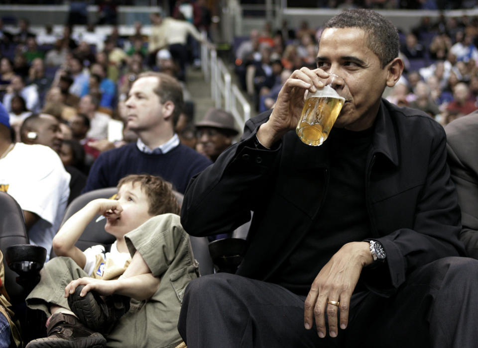 Obama, sitting next to 5-year-old Nick Aiello (L), sips his beverage while attending the Washington Wizards NBA basketball game against the Chicago Bulls in Washington, February 27, 2009.