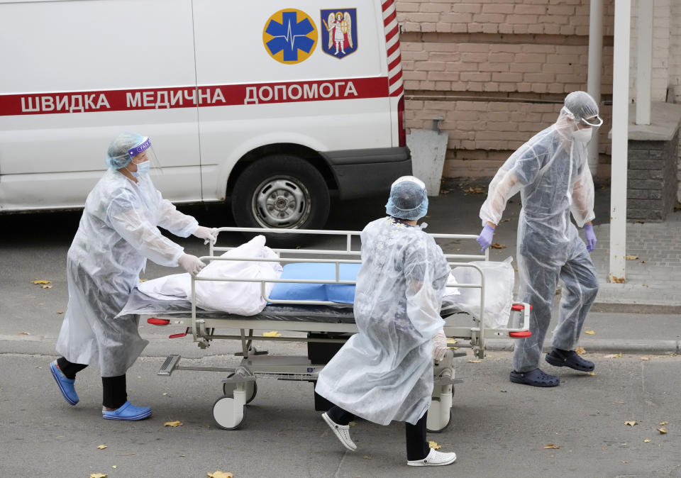 Medical staff members push a cart out of the COVID-19 infection department in a city clinic in Kyiv, Ukraine, Thursday, Oct. 21, 2021. Coronavirus infections and deaths in Ukraine have surged to all-time highs amid a laggard pace of vaccination, which is one of the lowest in Europe. Ukrainian authorities on Thursday reported over 22,000 new confirmed infections and 546 deaths in the past 24 hours, the highest numbers since the start of the pandemic. (AP Photo/Efrem Lukatsky)