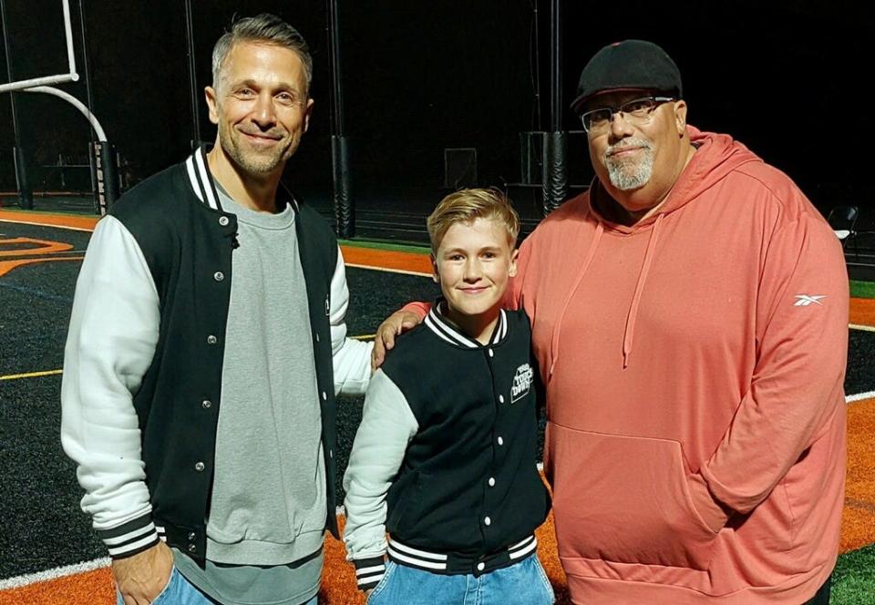 From left to right: “TOGGO Touchdown” hosts Florian Ambrosius, Mads Ambrosius and Taunton High School teacher and public address announcer Mike Fox pose following a non-league football game against Milton on Oct. 20, 2023.