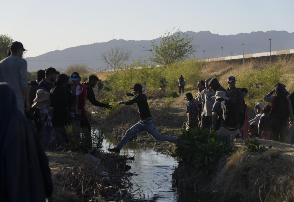 Migrants jump back and forth over the Rio Grande river into the United States and some back into Mexico, from Ciudad Juarez, Wednesday, March 29, 2023, a day after dozens of migrants died in a fire at a migrant detention center in Ciudad Juarez. (AP Photo/Fernando Llano)