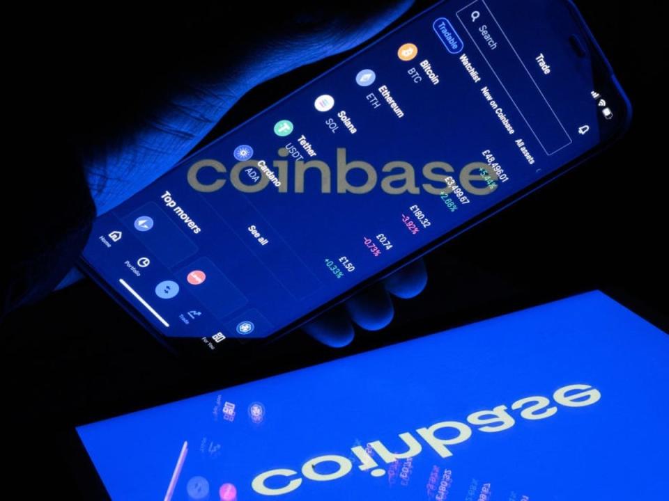A flipped version of the logo for the crypto exchange Coinbase is reflected in a mobile phone screen on 9 November, 2021 in London, England (Getty Images)