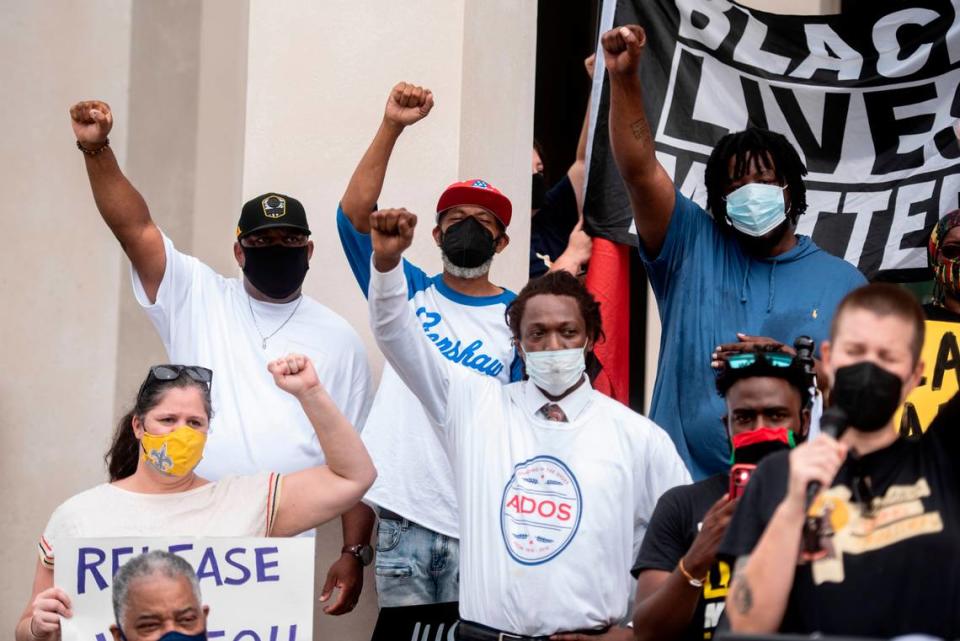 Supporters raise their fists outside Gulfport Police Department during a press conference demanding law enforcement transparency in the killing of infant La’Mello Parker on Wednesday, Sept. 8, 2021.