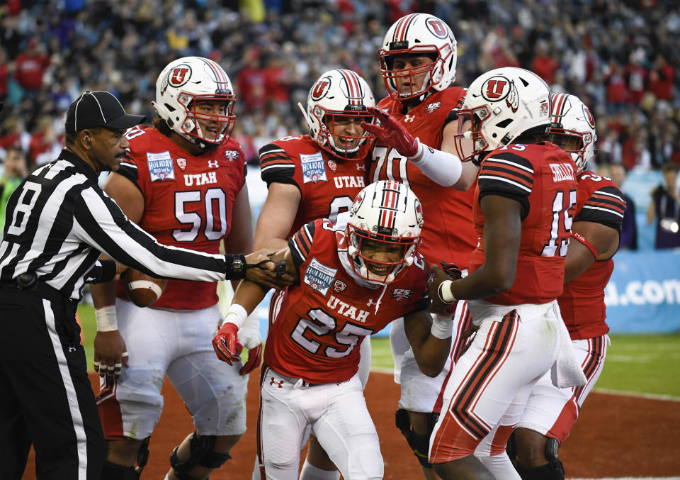 Utah players congratulate wide receiver Jaylen Dixon (25) after scoring a touchdown during the first half of the Holiday Bowl NCAA college football game against Northwestern, Monday, Dec. 31, 2018, in San Diego. (AP Photo/Denis Poroy)