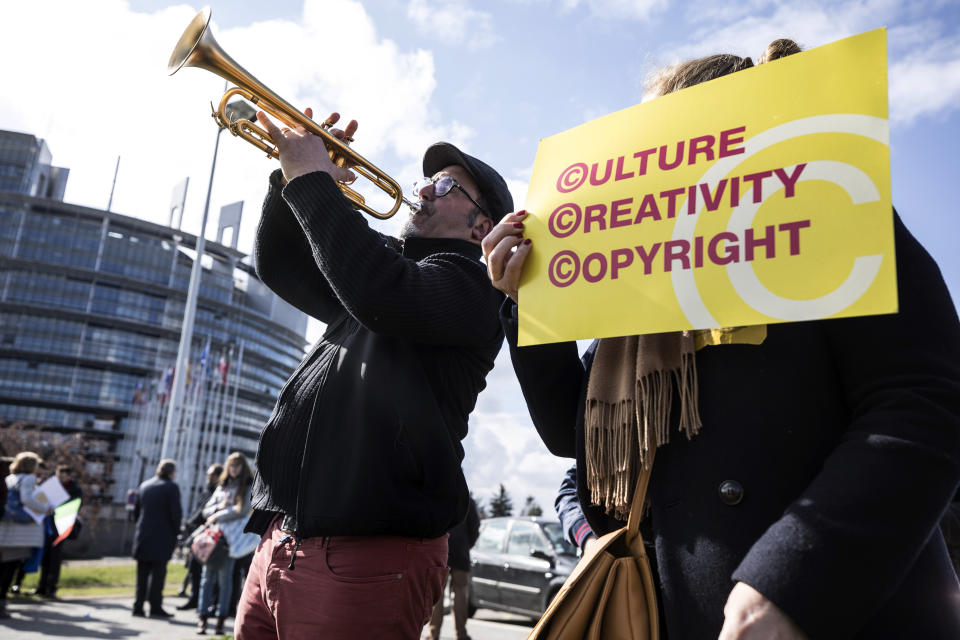 People gather at the front of the European Parliament building in Strasbourg, France, Tuesday March 26, 2019, to show their support for the copyright bill. The European Parliament is furiously debating the pros and cons of a landmark copyright bill one last time before the legislature will vote on it later. (AP Photo/Jean-Francois Badias)