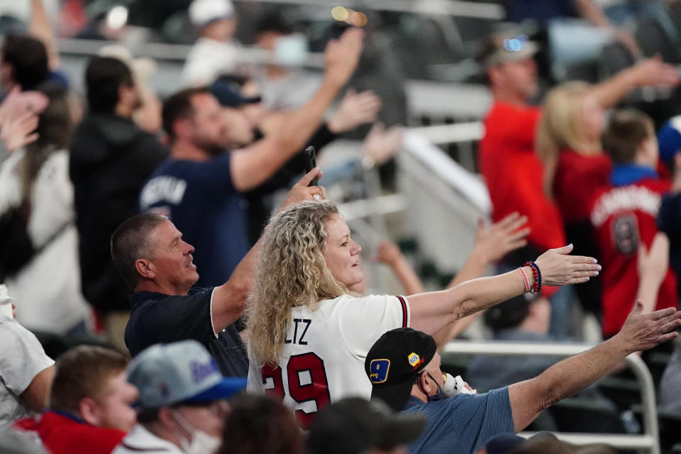 FILE - In this Saturday, April 10, 2021 file photo, Atlanta Braves fans do the Tomahawk Chop during a baseball game against the Philadelphia Phillies in Atlanta. As the World Series shifts to Atlanta, some TV viewers may be offended to see Braves fans still chopping and chanting. After teams in the NFL and Major League Baseball have dropped names viewed as offensive to Native Americans the last two years, the Braves chop on. The tomahawk chop has the support of baseball commissioner Rob Manfred. (AP Photo/John Bazemore, File)