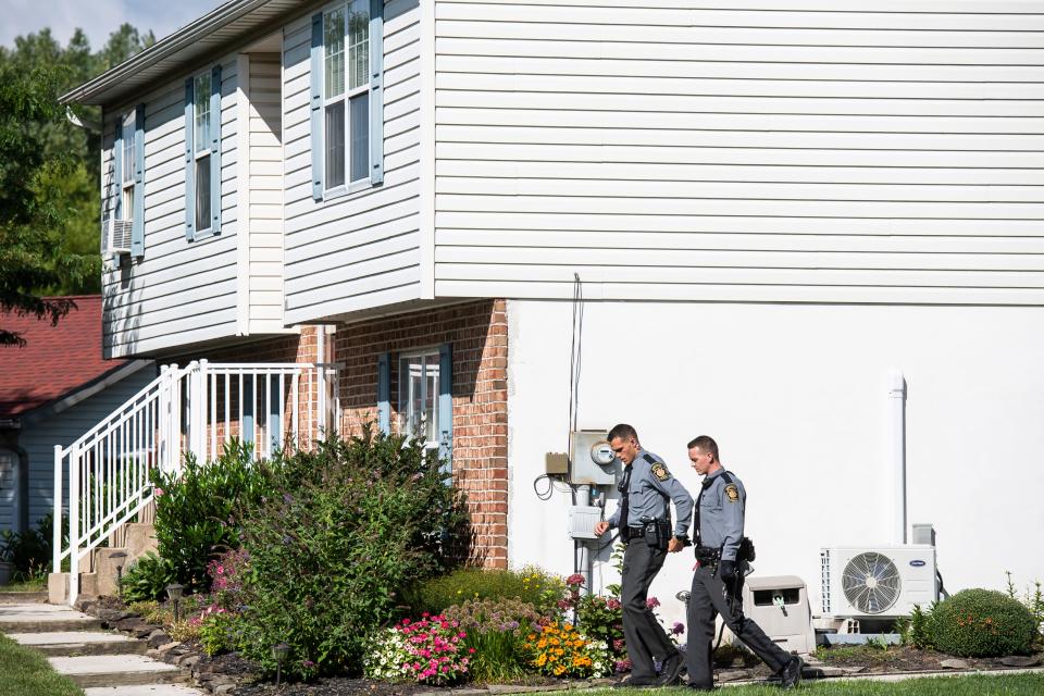 A pair of Pennsylvania State Police troopers exit the scene where a double fatal stabbing was reported in the first block of Firebox Court, in Hopewell Township. Police responded to the home shortly after 7:19 p.m. Monday and found a 34-year-old woman and a 5-year-old girl dead and two others seriously injured.