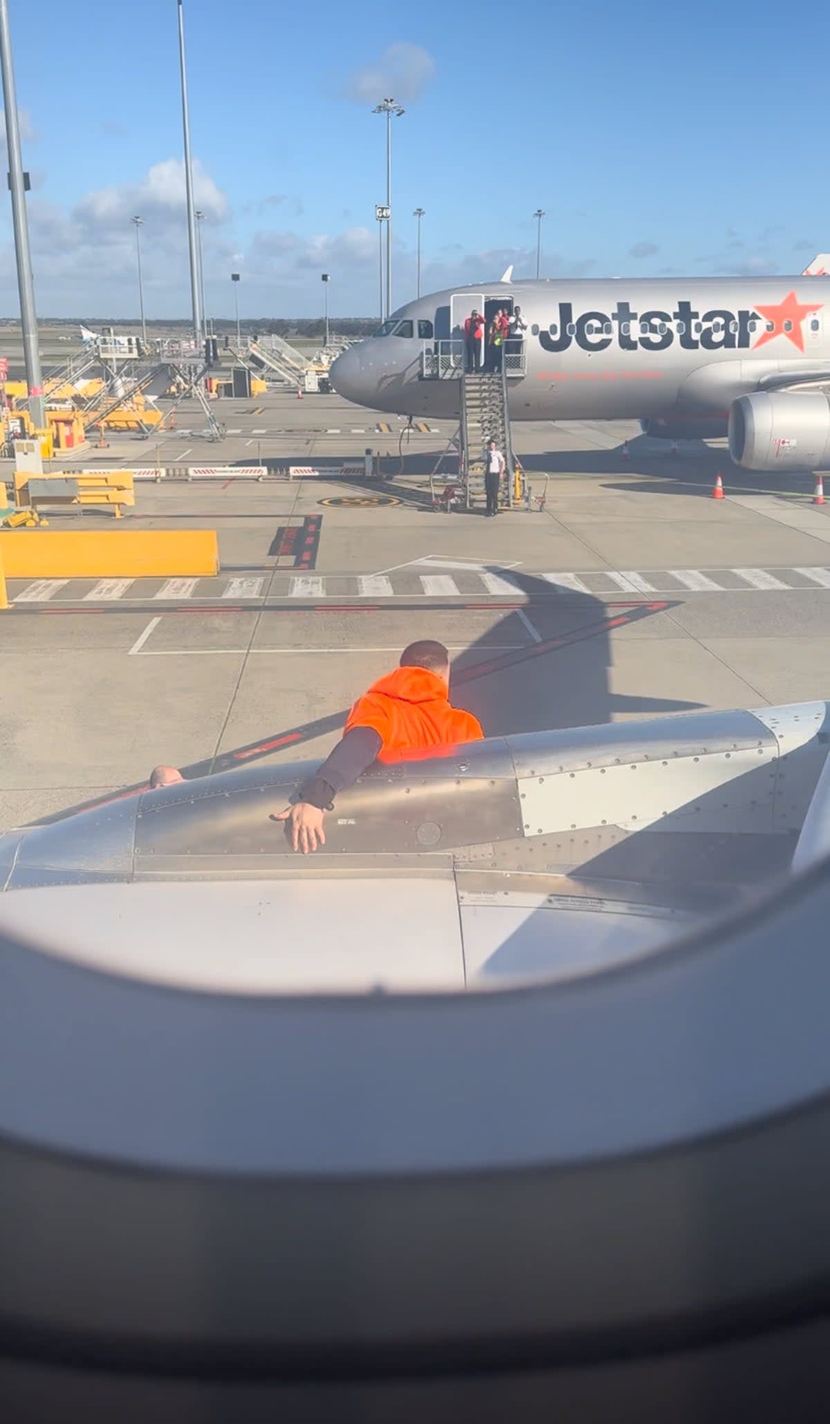 A man has been arrested after he opened a plane door and walked onto its wing (James Gordon/Twitter)