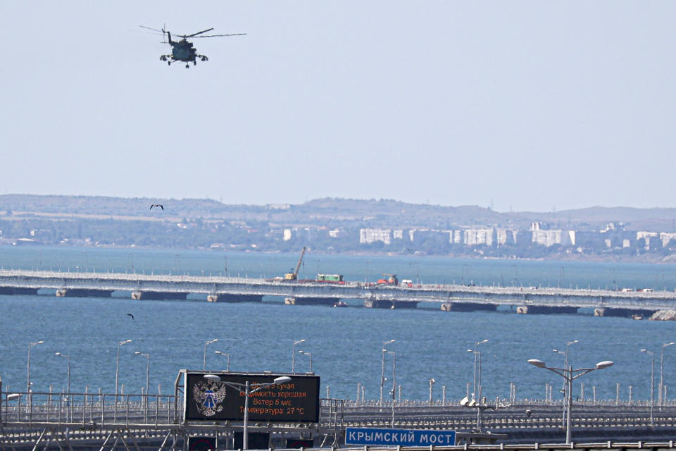 Image: A Russian military helicopter flies over damaged parts of the Crimean Bridge, which connects the Russian mainland to the Crimean peninsula and is a key supply route for the Russian war efforts in Ukraine, on July 17. (AP file)