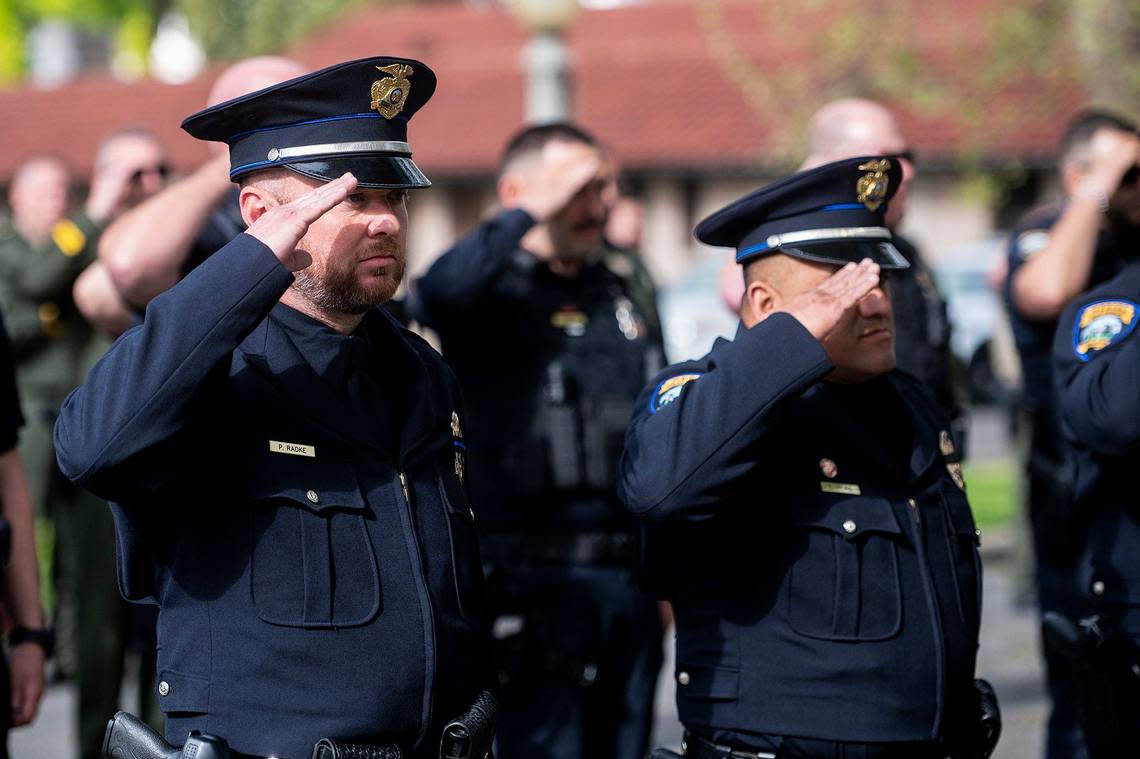 Merced police officers and fellow first responders salute during an annual ceremony to honor fallen Merced Police officer Stephan Gray at the Merced Police Station in Merced, Calif., on Monday, April 15, 2024. Gray was shot and killed in the line of duty on April 15, 2004.